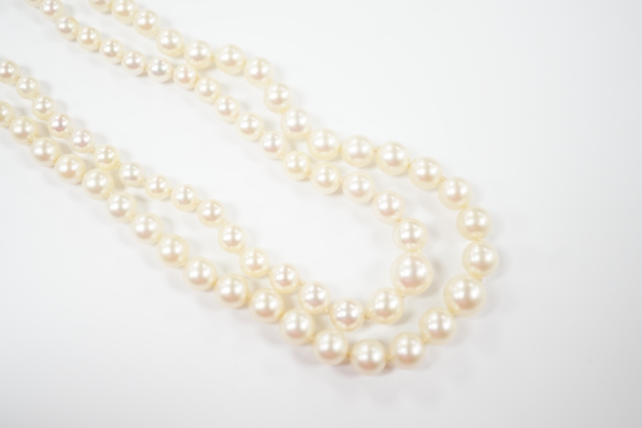 A double strand graduated cultured pearl necklace, with paste set white metal clasp, 44cm.